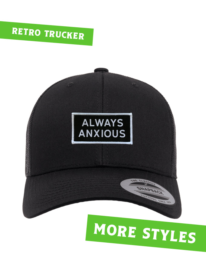 "Always Anxious" in white block text embroidered on black patch with white merrowed edge on a curved brim snap back.  Art by Print Ritual.