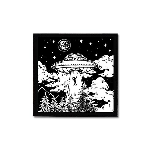 Screen printed image of person being pulled into a flying saucer at night amongst trees and mountains. White ink on black background. Art by Print Ritual.